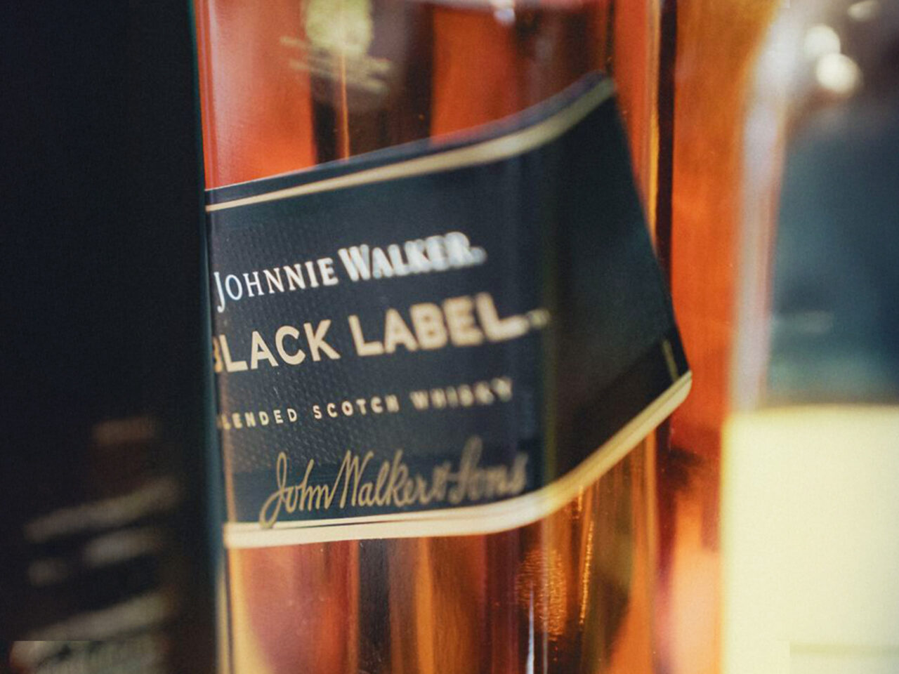 Close-up of a Johnnie Walker Black Label whisky bottle label on a wooden bottle surface.