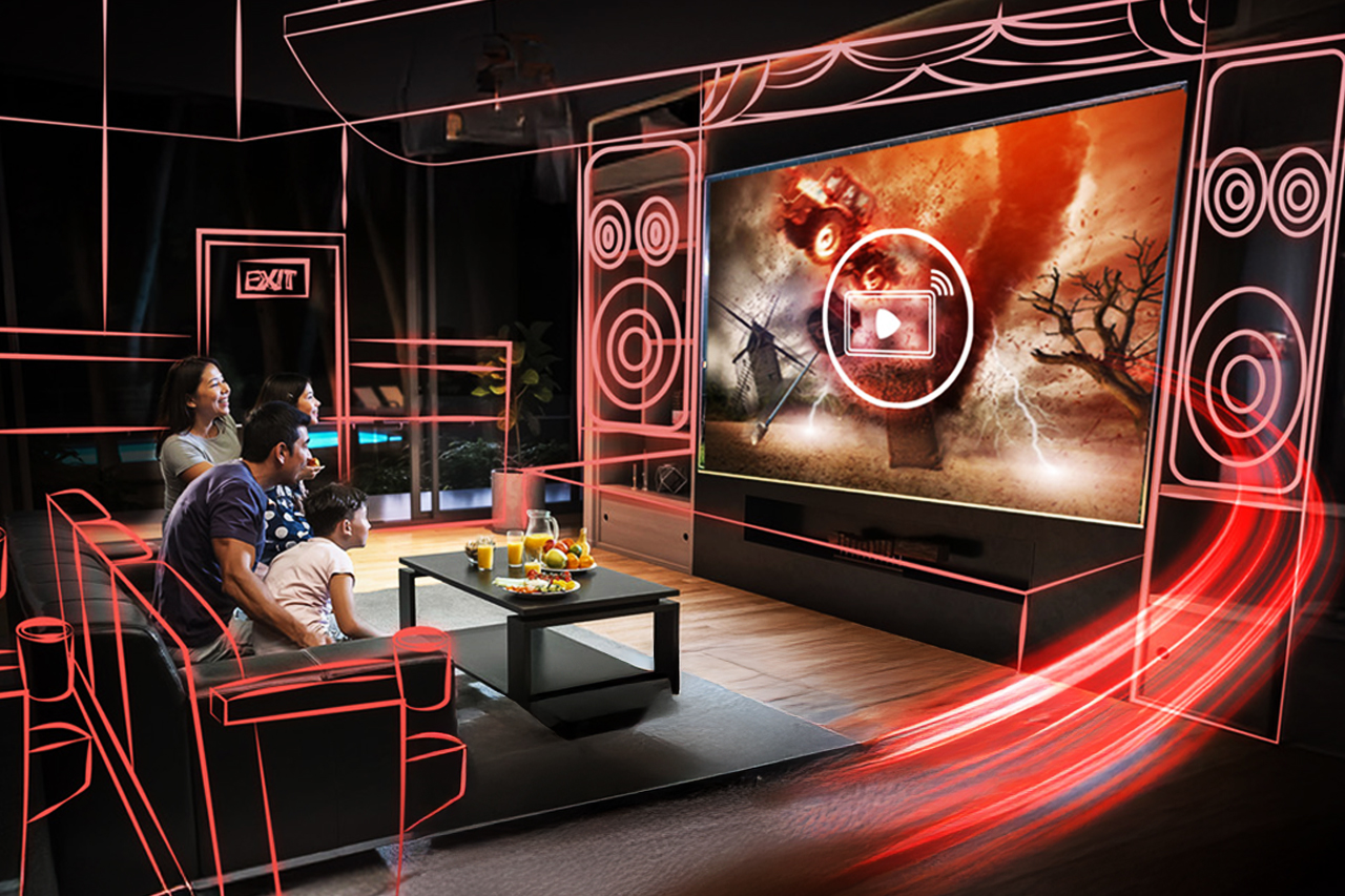 A family of four sits on a couch watching a large TV screen in a neon-outlined home theater setup with red glowing lines around the room.