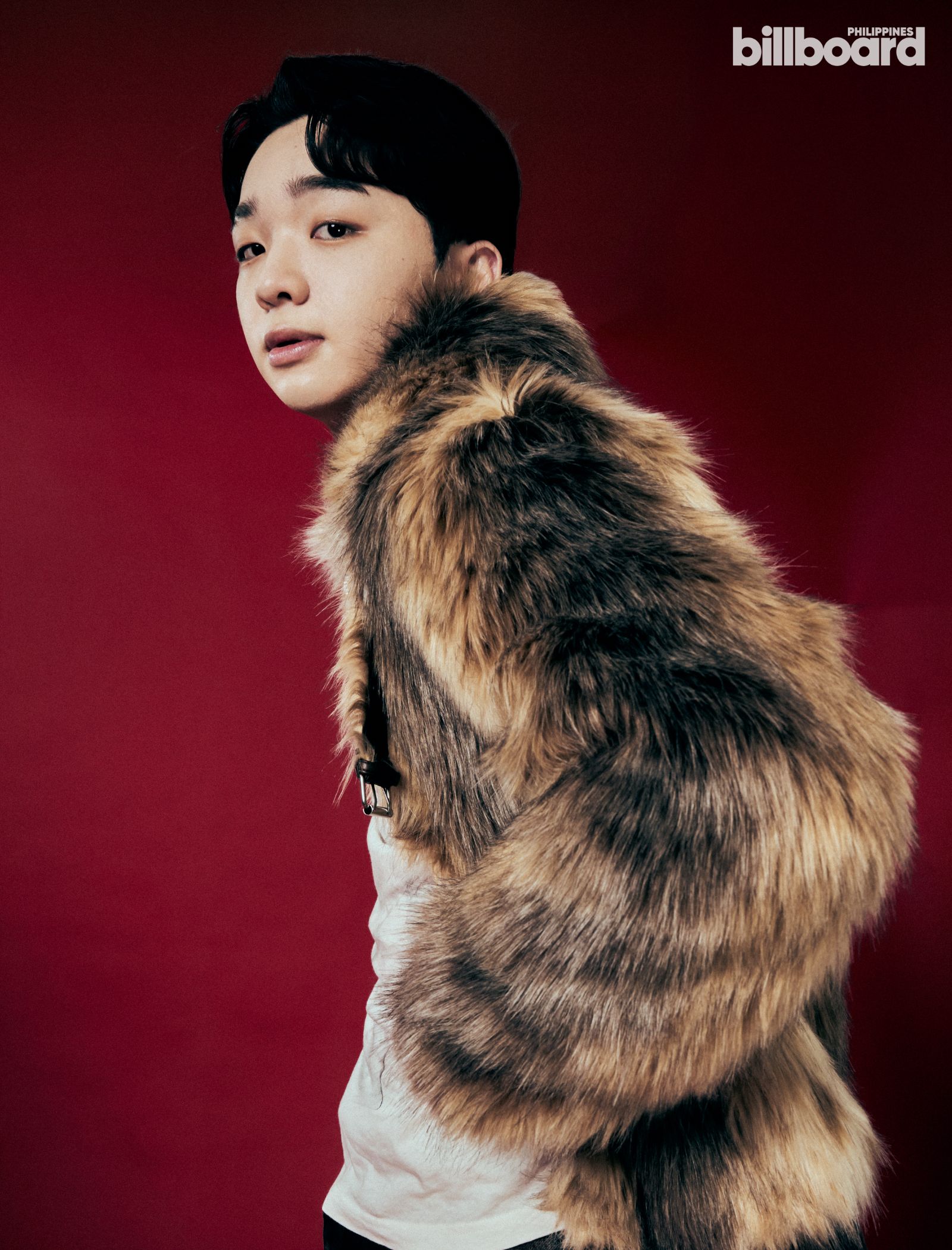 Portrait of a person wearing a thick fur coat against a red background, looking over their shoulder toward the camera (Billboard Philippines logo in corner).