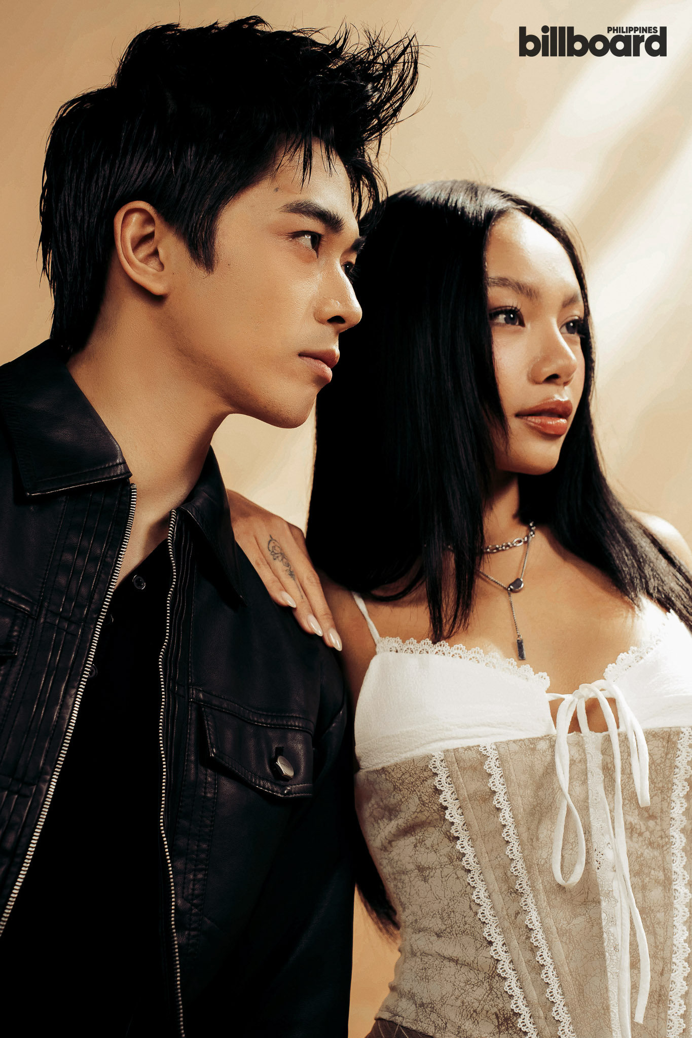 Man in a black leather jacket stands beside a woman in a white lace corset dress, both looking forward, with a Billboard Philippines logo in the top-right corner.