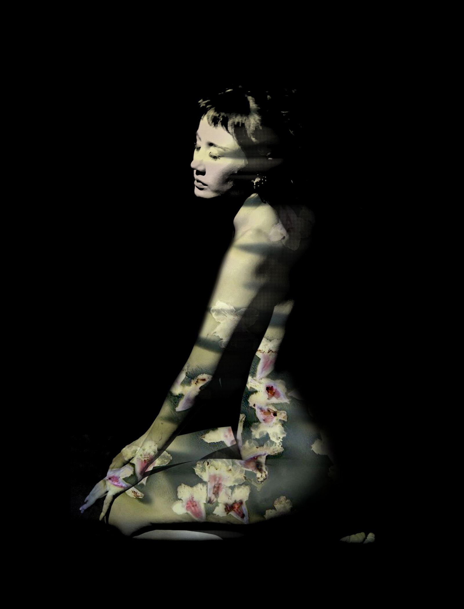 Artistic portrait of a woman in profile with a floral overlay on her dress against a black background